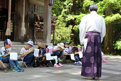 写真：真山神社の宮司さんからお話を聞く児童たち