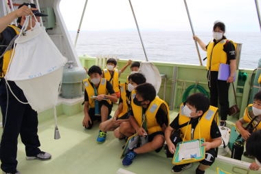 写真：船に乗り説明を聞く児童たち