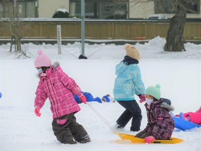写真：雪の中そりで遊ぶ児童たち1